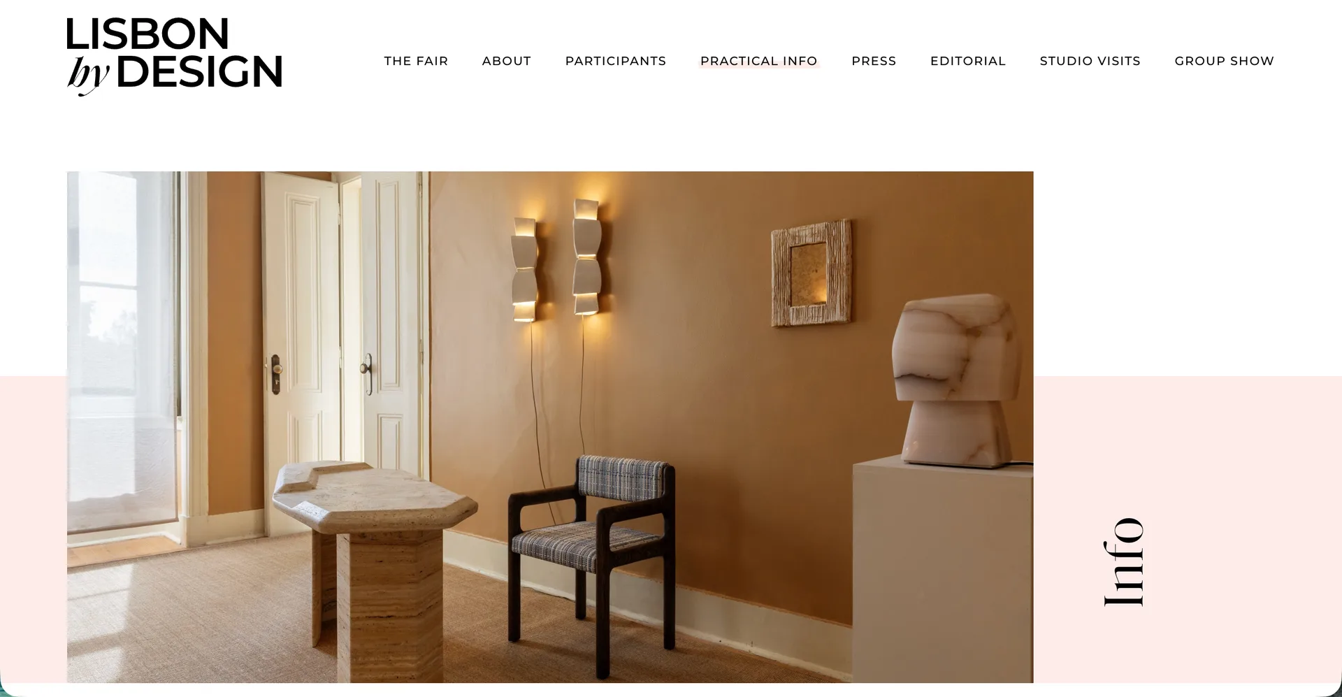 Lisbon by Design site: an exhibition room with a stone side table, an upholstered chair and a sculptural bust, beside the fair's information navigation